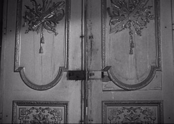 Movie still from “Decision Before Dawn” (1951), directed by Anatole Litvak – An old wooden door with a bird on it; Extreme Close Up shot, Overhead angle