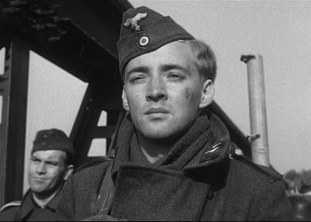 Movie still from “Decision Before Dawn” (1951), directed by Anatole Litvak – A man in a military uniform with a hat on; Close Up shot, Low angle