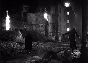 Movie still from “Decision Before Dawn” (1951), directed by Anatole Litvak – Two people are standing in the middle of the ruins of a building; Wide shot, Low angle
