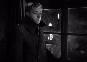Movie still from “Decision Before Dawn” (1951), directed by Anatole Litvak – Black and white photograph of a young man looking out of a window; Close Up shot, Low angle