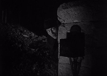 Movie still from “Decision Before Dawn” (1951), directed by Anatole Litvak – A man standing in front of a stone wall; Medium shot, Low angle