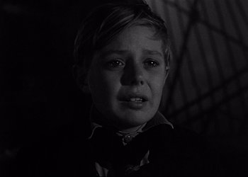 Movie still from “Decision Before Dawn” (1951), directed by Anatole Litvak – A young boy in a black and white photo; Close Up shot, Low angle
