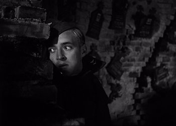 Movie still from “Decision Before Dawn” (1951), directed by Anatole Litvak – A man standing next to a brick wall; Close Up shot, Low angle