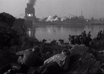 Movie still from “Decision Before Dawn” (1951), directed by Anatole Litvak – A black and white photo of a group of soldiers on a beach; Extreme Wide shot, High angle