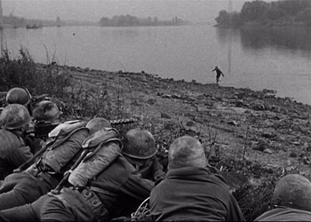 Movie still from “Decision Before Dawn” (1951), directed by Anatole Litvak – A black and white photo of soldiers in a field; Wide shot, High angle