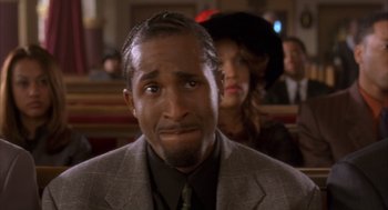 Movie still from “Deliver Us from Eva” (2003), directed by Gary Hardwick – A person wearing a suit and tie; Close Up shot, Low angle