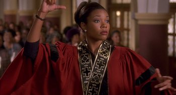 Movie still from “Deliver Us from Eva” (2003), directed by Gary Hardwick – A woman in a red robe is holding her hand up; Medium shot, Low angle