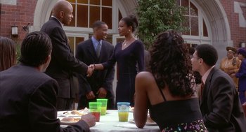 Movie still from “Deliver Us from Eva” (2003), directed by Gary Hardwick – A man and a woman shaking hands over a table; Medium shot, Over the shoulder angle