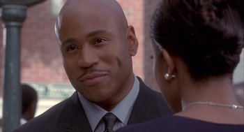 Movie still from “Deliver Us from Eva” (2003), directed by Gary Hardwick – A man in a suit and tie talking to a woman in a suit; Close Up shot, Over the shoulder angle