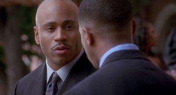 Movie still from “Deliver Us from Eva” (2003), directed by Gary Hardwick – A man in a suit and tie looking at another man in a suit and tie; Close Up shot, Over the shoulder angle