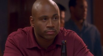 Movie still from “Deliver Us from Eva” (2003), directed by Gary Hardwick – A man with a bald head sitting in front of a beer; Close Up shot, High angle