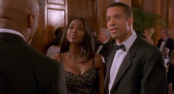 Movie still from “Deliver Us from Eva” (2003), directed by Gary Hardwick – A man and a woman standing next to each other in formal wear; Medium shot, Over the shoulder angle