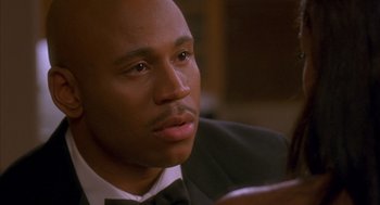 Movie still from “Deliver Us from Eva” (2003), directed by Gary Hardwick – A person wearing a suit and bow tie; Close Up shot, Over the shoulder angle
