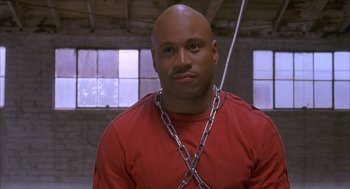 Movie still from “Deliver Us from Eva” (2003), directed by Gary Hardwick – A bald man wearing a chain around his neck; Close Up shot, Low angle