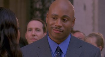 Movie still from “Deliver Us from Eva” (2003), directed by Gary Hardwick – A man that is wearing a suit and a tie; Close Up shot, Over the shoulder angle