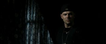 Movie still from “Deliver Us from Evil” (2014), directed by Scott Derrickson – A man wearing a black hat and a black shirt; Close Up shot, Over the shoulder angle