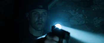 Movie still from “Deliver Us from Evil” (2014), directed by Scott Derrickson – A man is holding a flashlight and looking at the camera; Close Up shot, Low angle