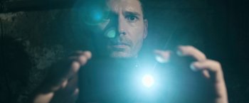 Movie still from “Deliver Us from Evil” (2014), directed by Scott Derrickson – A person looking at a camera lens; Close Up shot, Low angle