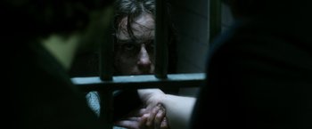 Movie still from “Deliver Us from Evil” (2014), directed by Scott Derrickson – A man in a jail cell holding onto the bars of his jail cell; Close Up shot, Overhead angle