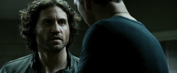 Movie still from “Deliver Us from Evil” (2014), directed by Scott Derrickson – Two men are talking to each other in a dark room; Close Up shot, Over the shoulder angle