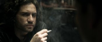 Movie still from “Deliver Us from Evil” (2014), directed by Scott Derrickson – A man smoking a cigarette while looking at the camera; Close Up shot, Over the shoulder angle