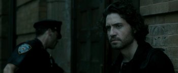 Movie still from “Deliver Us from Evil” (2014), directed by Scott Derrickson – A man standing next to another man in front of a building; Close Up shot, Over the shoulder angle