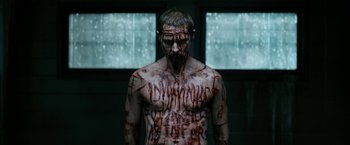 Movie still from “Deliver Us from Evil” (2014), directed by Scott Derrickson – A man with blood all over his face and chest; Medium shot, Over the shoulder angle