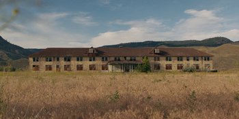 Movie still from “Demonic” (2021), directed by Neill Blomkamp – An abandoned building in the middle of a field; Extreme Wide shot, Low angle