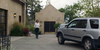 Movie still from “Demonic” (2021), directed by Neill Blomkamp – A woman walking down the street while holding a cell phone; Wide shot, Low angle