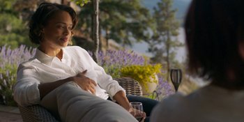 Movie still from “Demonic” (2021), directed by Neill Blomkamp – A woman sitting on top of an outdoor couch; Medium shot, Over the shoulder angle