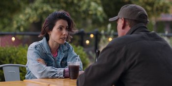 Movie still from “Demonic” (2021), directed by Neill Blomkamp – A woman sitting at a table talking to a man; Close Up shot, Over the shoulder angle