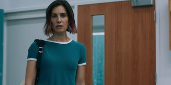 Movie still from “Demonic” (2021), directed by Neill Blomkamp – A woman standing in front of a wooden door; Medium shot, Over the shoulder angle