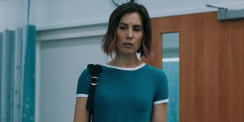 Movie still from “Demonic” (2021), directed by Neill Blomkamp – A woman in a blue t - shirt holding a black bag; Close Up shot, Low angle