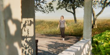 Movie still from “Demonic” (2021), directed by Neill Blomkamp – A woman walking down a road near some trees; Wide shot, Over the shoulder angle