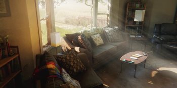 Movie still from “Demonic” (2021), directed by Neill Blomkamp – The sun shines through the window of a living room; Wide shot, High angle