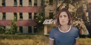 Movie still from “Demonic” (2021), directed by Neill Blomkamp – A woman standing in front of an abandoned building; Medium shot, Over the shoulder angle