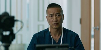 Movie still from “Demonic” (2021), directed by Neill Blomkamp – A man in a blue shirt is sitting in front of a computer; Close Up shot, Over the shoulder angle