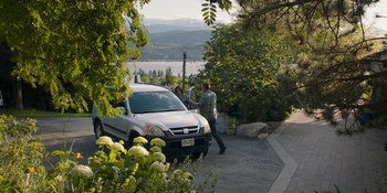 Movie still from “Demonic” (2021), directed by Neill Blomkamp – Two men and a car on a sidewalk near a lake; Wide shot, High angle
