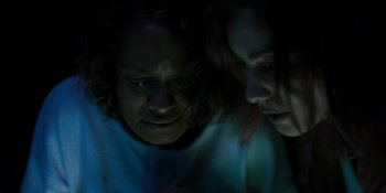 Movie still from “Demonic” (2021), directed by Neill Blomkamp – A couple of people that are in the dark; Close Up shot, High angle