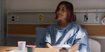 Movie still from “Demonic” (2021), directed by Neill Blomkamp – A woman sitting at a table in a hospital room; Medium shot, Over the shoulder angle