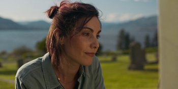 Movie still from “Demonic” (2021), directed by Neill Blomkamp – A person sitting in a field; Close Up shot, Over the shoulder angle