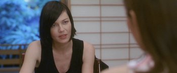 Movie still from “Demonlover” (2002), directed by Olivier Assayas – A woman sitting in front of a camera; Close Up shot, Over the shoulder angle