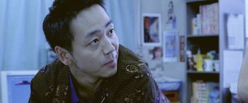 Movie still from “Demonlover” (2002), directed by Olivier Assayas – A person with a cigarette in his mouth; Close Up shot, Over the shoulder angle