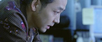 Movie still from “Demonlover” (2002), directed by Olivier Assayas – A man's face looking down; Close Up shot, Low angle