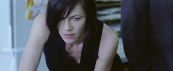 Movie still from “Demonlover” (2002), directed by Olivier Assayas – A person sitting on the ground; Close Up shot, Low angle