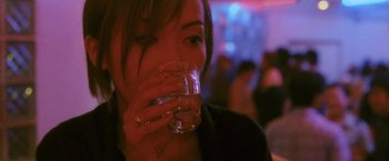 Movie still from “Demonlover” (2002), directed by Olivier Assayas – A person holding a glass of water; Close Up shot, Over the shoulder angle