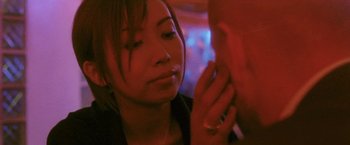 Movie still from “Demonlover” (2002), directed by Olivier Assayas – A young woman holding her hand up to her face; Close Up shot, Over the shoulder angle