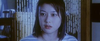 Movie still from “Demonlover” (2002), directed by Olivier Assayas – A woman's face in front of a television screen; Close Up shot, Low angle