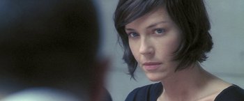 Movie still from “Demonlover” (2002), directed by Olivier Assayas – A person looking at the camera; Close Up shot, Over the shoulder angle