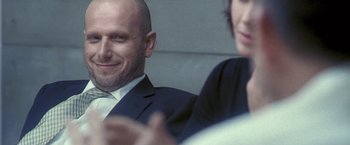 Movie still from “Demonlover” (2002), directed by Olivier Assayas – A man and a woman sitting in front of each other; Close Up shot, Low angle